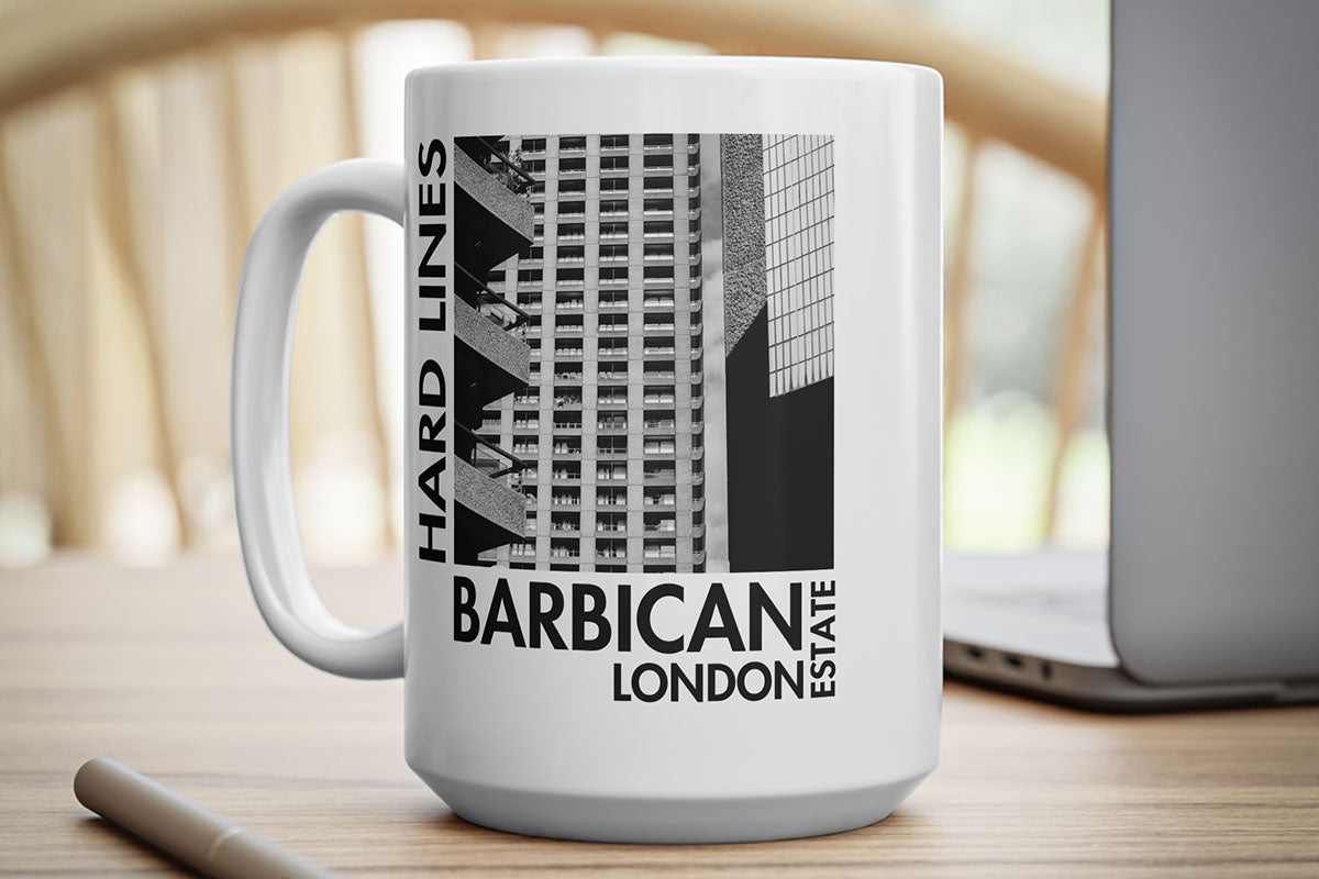 White mug with Barbican Estate design on a wooden surface